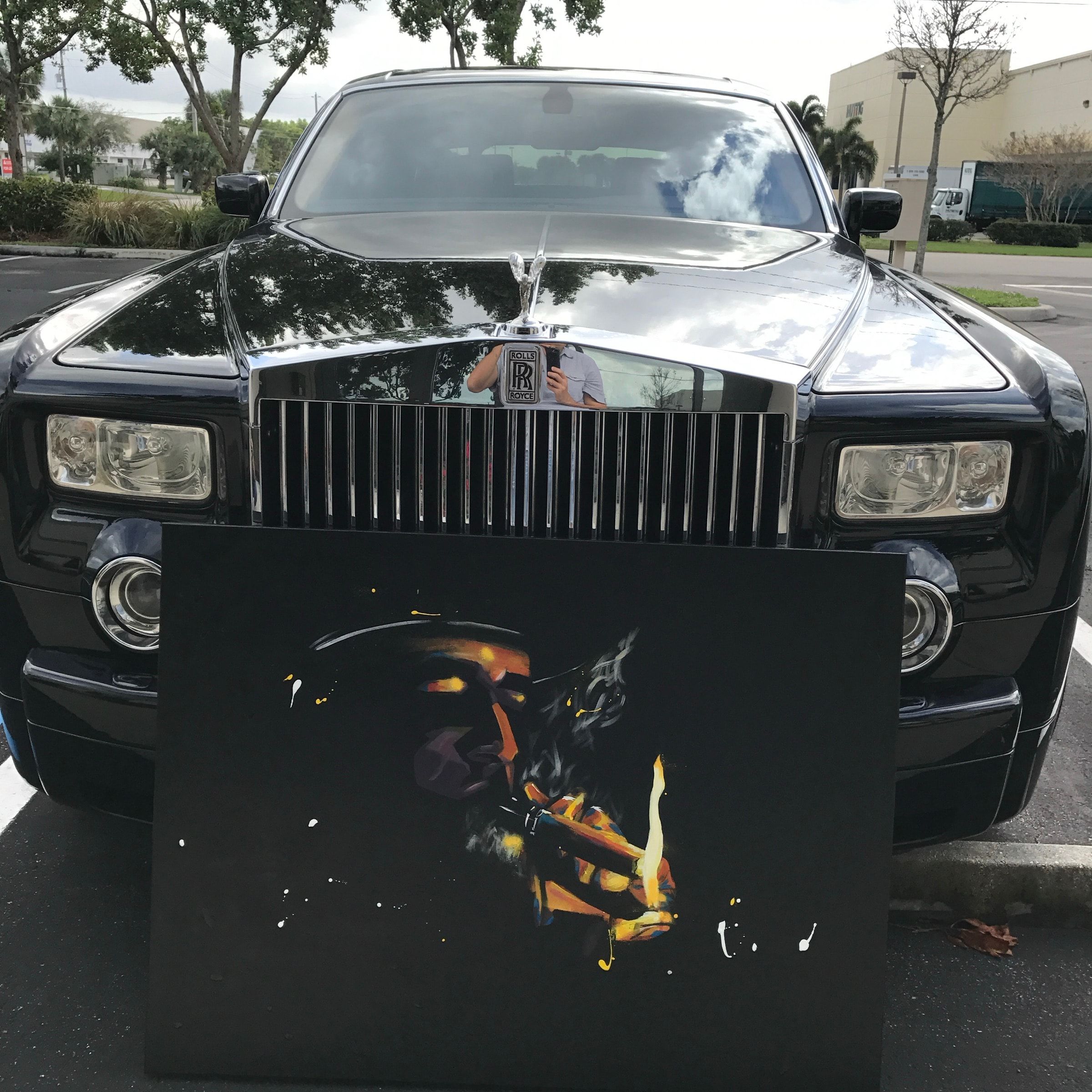Close view of the gold-on-black cigar painting in front of a Rolls-Royce grille