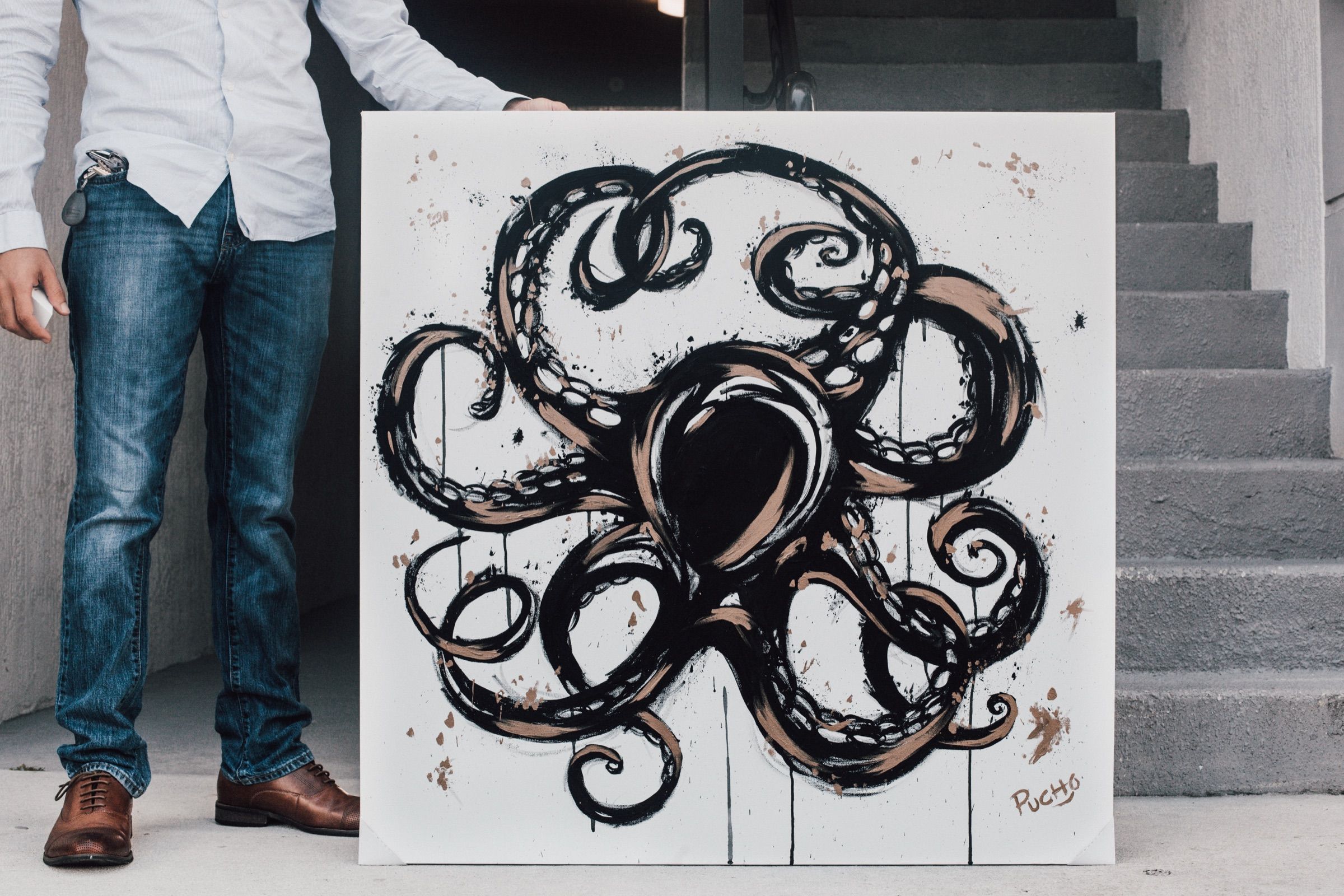 PUCHO painting of an octopus in bold black brushwork with copper accents on a white canvas